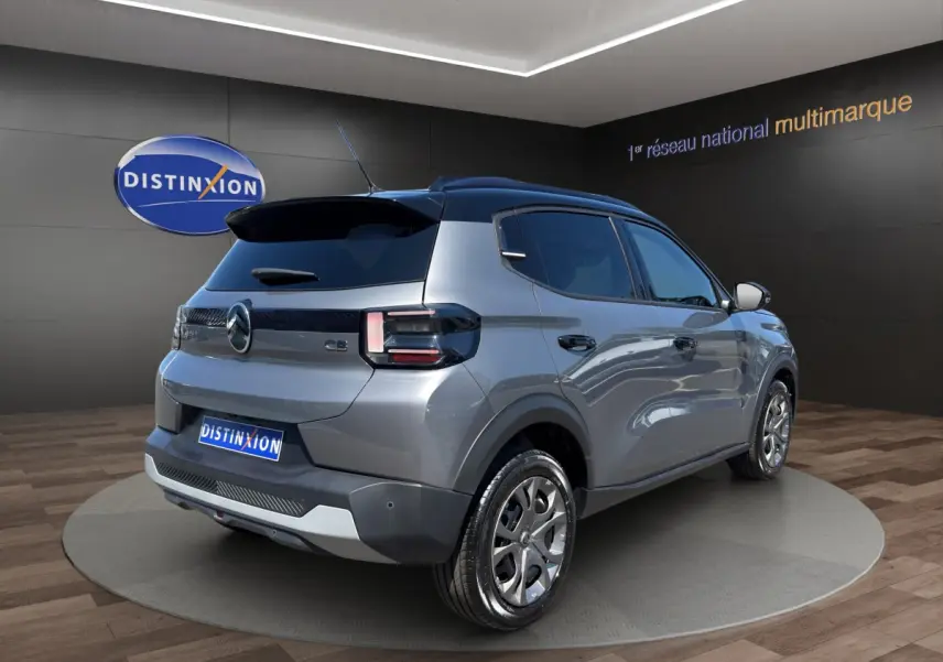 Vue 3/4 arrière droite d'une Citroën C3 hybride gris foncé avec toit noir et feux arrière LED distinctifs.