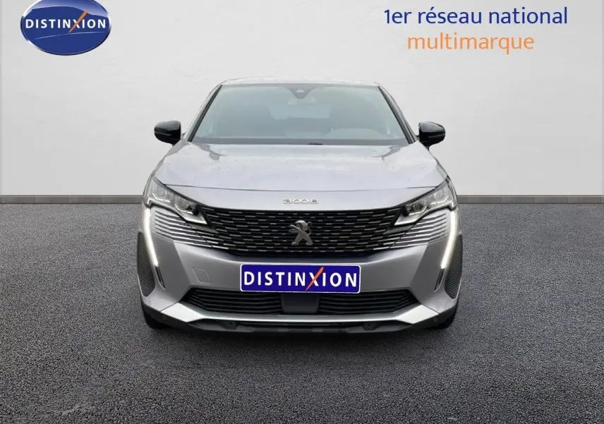 Vue frontale d'un Peugeot 3008 gris Artense métal 2024 avec calandre noire et feux LED verticaux allumés.