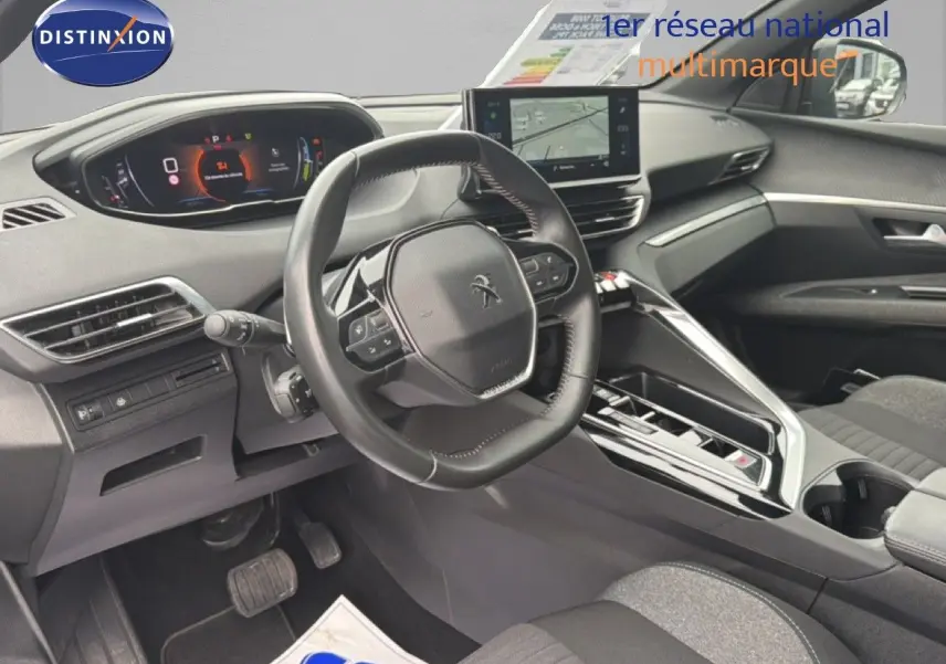 Intérieur avant du Peugeot 5008 Hybrid 2024, vue côté conducteur, tableau de bord numérique et volant compact noir.