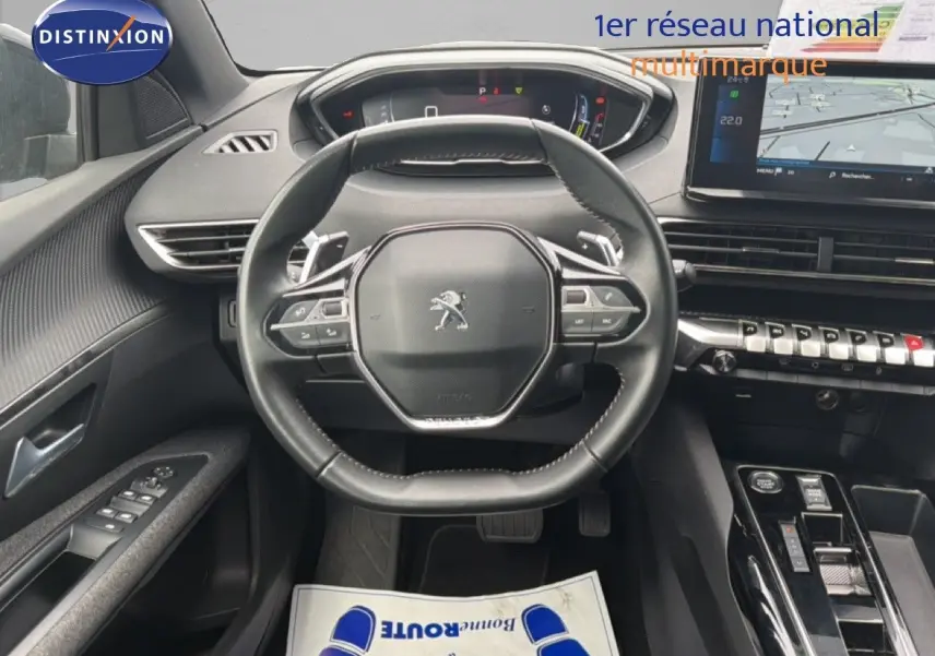 Vue intérieure centrée sur le volant cuir multifonction du Peugeot 5008 2024, tableau de bord et écran tactile visibles.