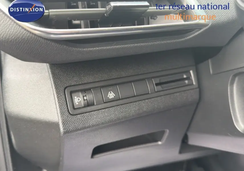 Détail du tableau de bord noir du Peugeot 5008 Hybrid 2024, avec commandes d'éclairage et aide à la conduite.