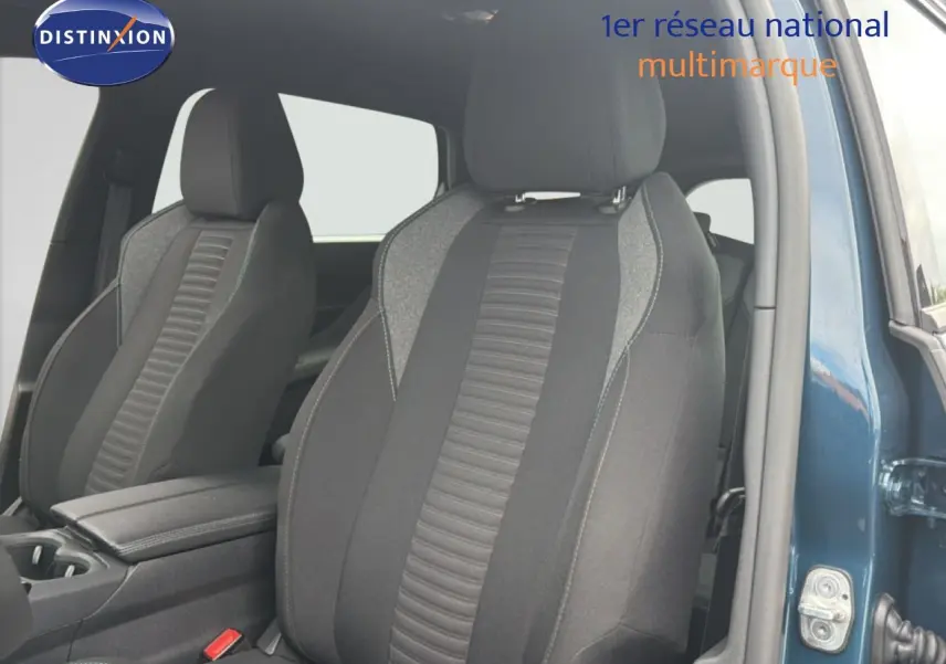 Vue intérieure sur les sièges avant en tissu gris noir du Peugeot 5008 bleu Célèbes métal, porte avant droite ouverte.
