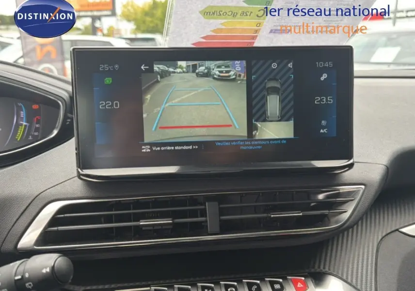 Vue intérieure du tableau de bord du Peugeot 5008 bleu Celebes Metal, écran central affichant la caméra de recul et la climatisation.