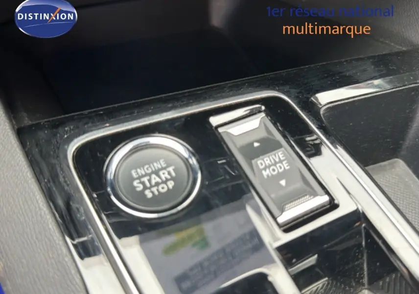 Gros plan sur la console centrale du Peugeot 5008 Hybrid 2024 avec bouton start/stop et commande drive mode.
