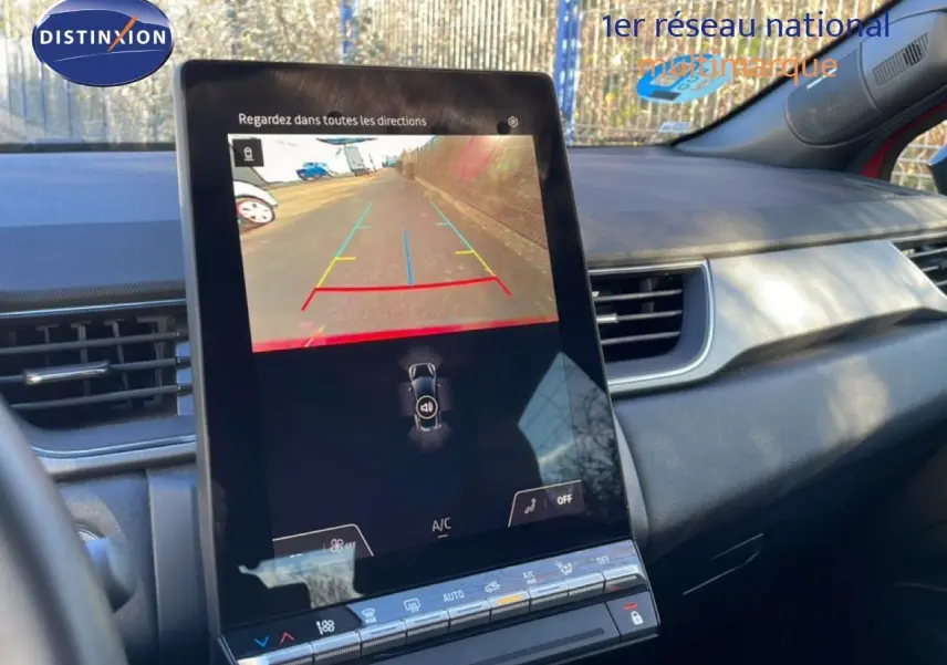 Vue intérieure centrée sur l'écran tactile affichant la caméra de recul du Renault Captur rouge Désir métal avec toit noir.
