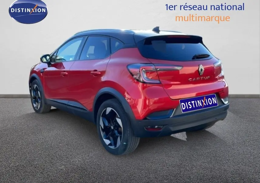 Vue 3/4 arrière droite d’un Renault Captur rouge désir métal avec toit noir et jantes noires brillantes.