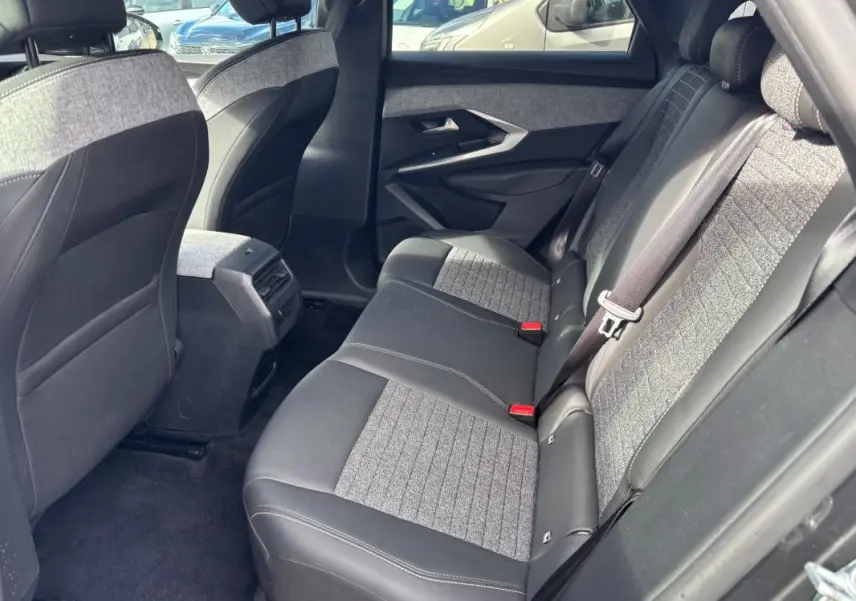 Vue intérieure arrière côté droit du Peugeot 3008 Hybrid 145 e-DCS6 Allure 2025, sièges bi-matière gris et noir.