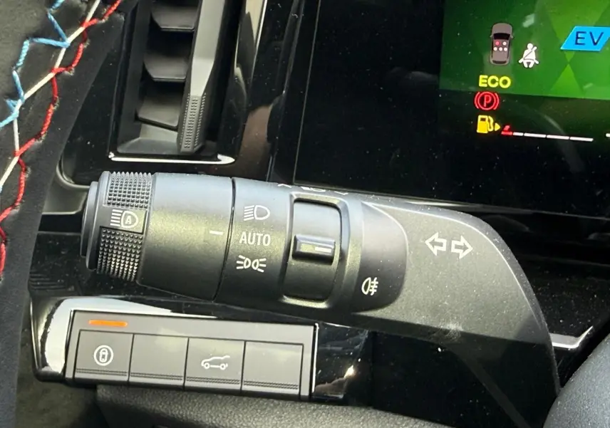 Gros plan sur la commande des feux et clignotants à gauche du volant dans l’habitacle noir du Renault Austral 2026.