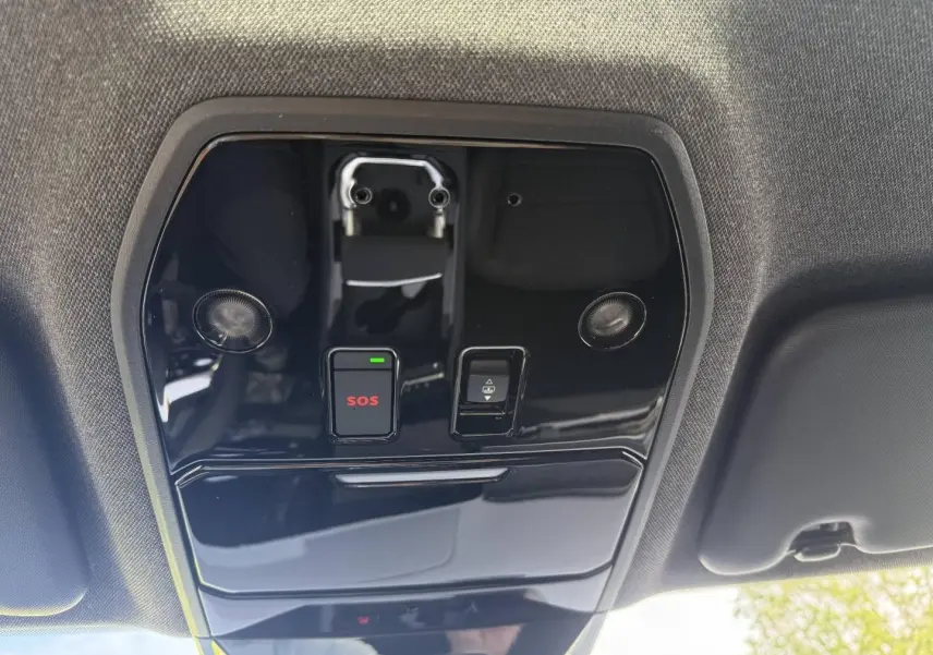 Vue en contre-plongée du panneau de commande intérieur noir brillant avec bouton SOS rouge et éclairage intégré sur Renault Austral 2026.