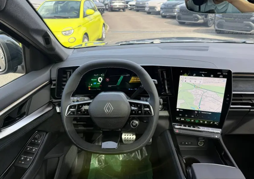 Vue intérieure du tableau de bord du Renault Austral 2026, volant multifonction et écran tactile central avec navigation visible.