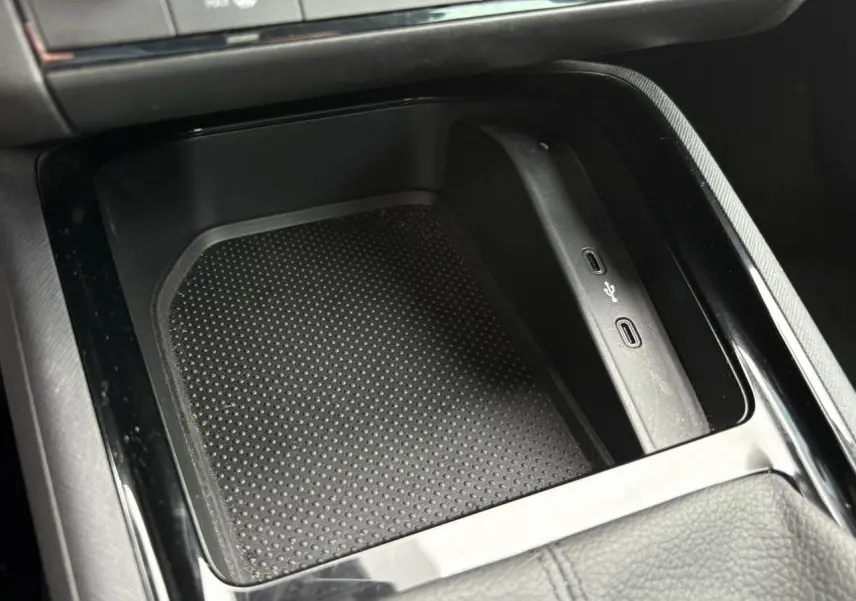 Gros plan sur la console centrale du Skoda Kamiq rouge Velvet 2024, montrant les ports USB et un espace de rangement noir texturé.