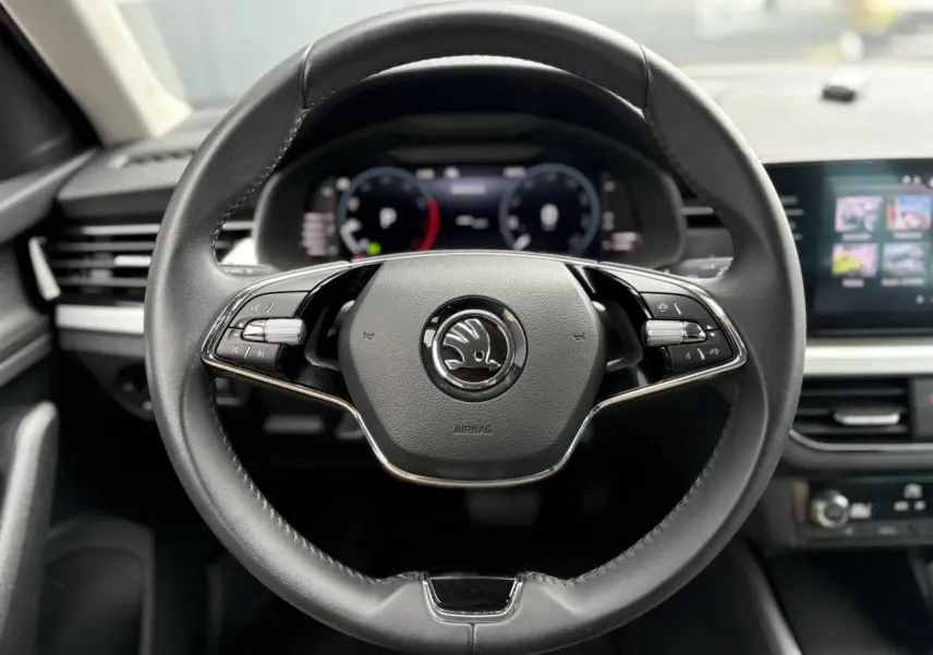 Volant cuir noir multifonctions de la Skoda Kamiq 2024 avec Digital Cockpit et écran tactile visible en arrière-plan.