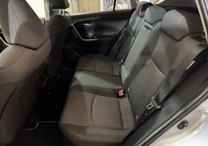Vue côté droit de la banquette arrière noire du Toyota RAV4 hybride 2021 avec ceinture et appuie-têtes visibles.