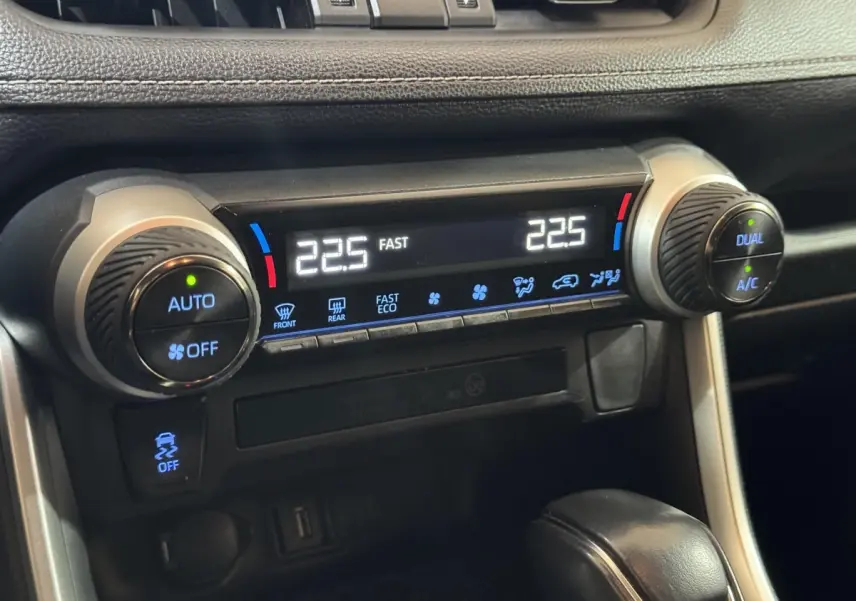 Détail de la climatisation digitale avec réglages dual zone sur tableau de bord noir du Toyota RAV4 gris clair hybride 2021