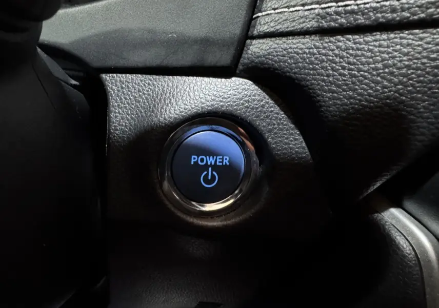 Bouton démarrage Power éclairé en bleu sur tableau de bord noir du Toyota RAV4 Hybride 2021.