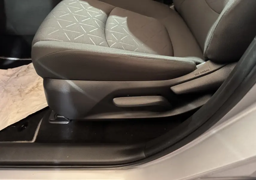 Gros plan sur le siège conducteur gris clair du Toyota RAV4 hybride 2021, avec étiquette SRS Airbag visible sur le côté.