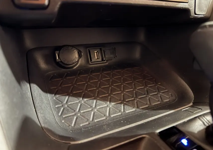 Prise USB et allume-cigare dans le compartiment avant du Toyota RAV4 hybride gris clair 2021.