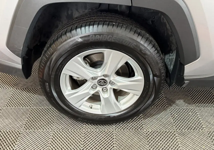 Gros plan sur la roue avant droite gris clair du Toyota RAV4 hybride 2021 avec jante alliage et pneu Bridgestone.