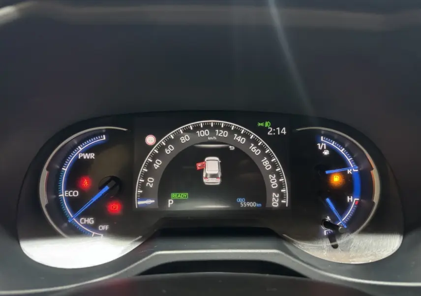 Tableau de bord numérique du Toyota RAV4 hybride 2021 montrant la vitesse, jauges et alertes au centre du véhicule.