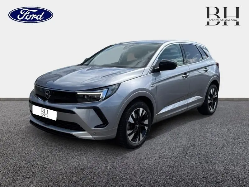 Opel Grandland gris Kontrast métallisé vu en 3/4 avant droit avec jantes alu noires et phares LED.