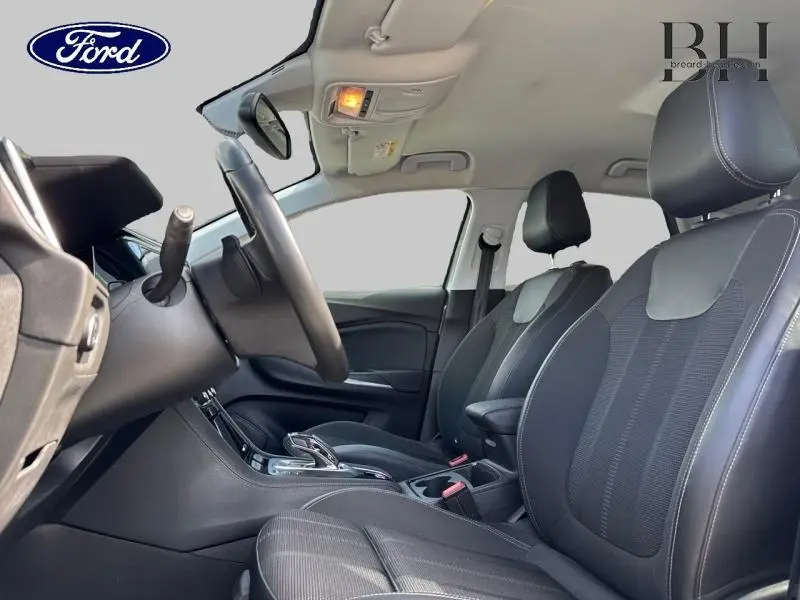 Vue intérieure côté conducteur de l’Opel Grandland 2023, sièges tissu noir avec volant cuir multifonction.