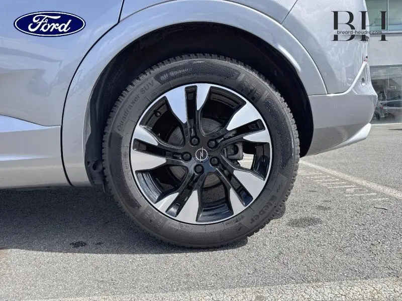 Gros plan sur la roue avant droite de l’Opel Grandland gris Kontrast métallisé avec jante alu bicolore.