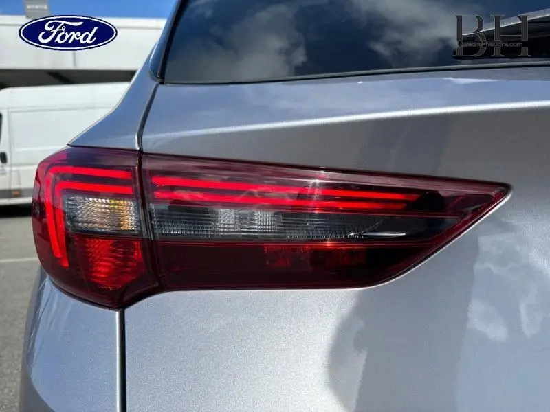 Gros plan sur le feu arrière droit d'un Opel Grandland gris Kontrast métallisé 2023, avec détails lumineux rouges et blancs.