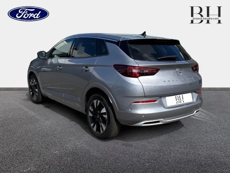 Opel Grandland gris Kontrast métallisé vu en 3/4 arrière droit, avec jantes alliage et feux arrière LED.