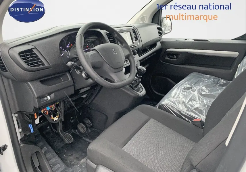 Vue intérieure côté conducteur du Peugeot Expert Long 2023, montrant le volant, tableau de bord et siège avant gris.