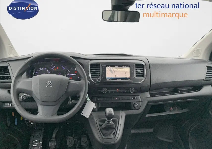 Vue intérieure frontale du tableau de bord noir du Peugeot Expert Long 2023 avec volant, écran tactile et boîte manuelle.