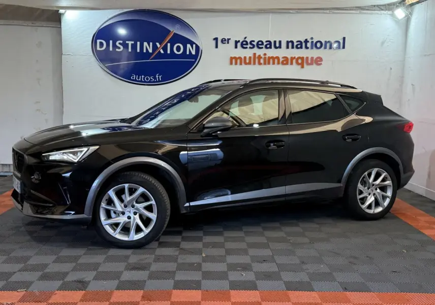 Profil côté gauche d'un SUV CUPRA Formentor noir 2023 avec jantes argentées, dans un showroom intérieur.