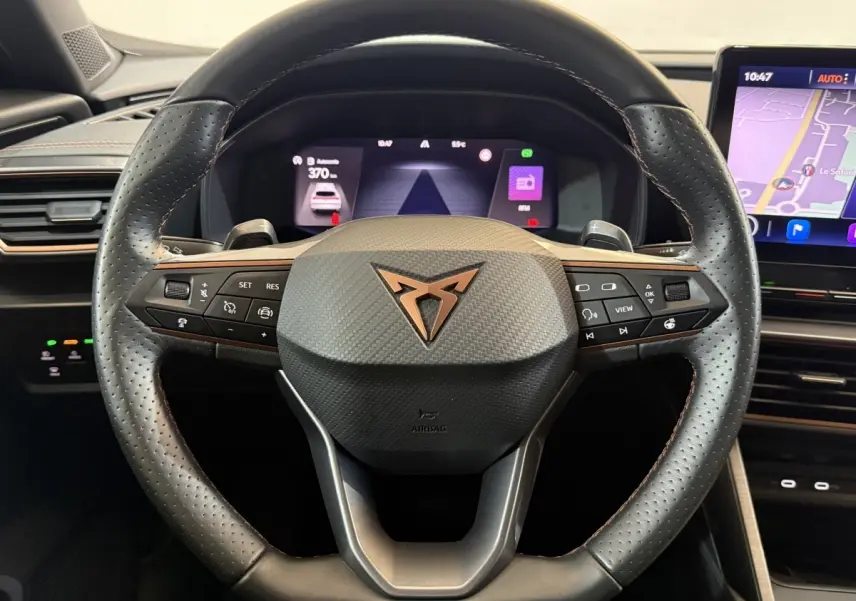 Vue rapprochée du volant cuir noir perforé avec logo CUPRA cuivré et tableau de bord digital du Formentor 2023.