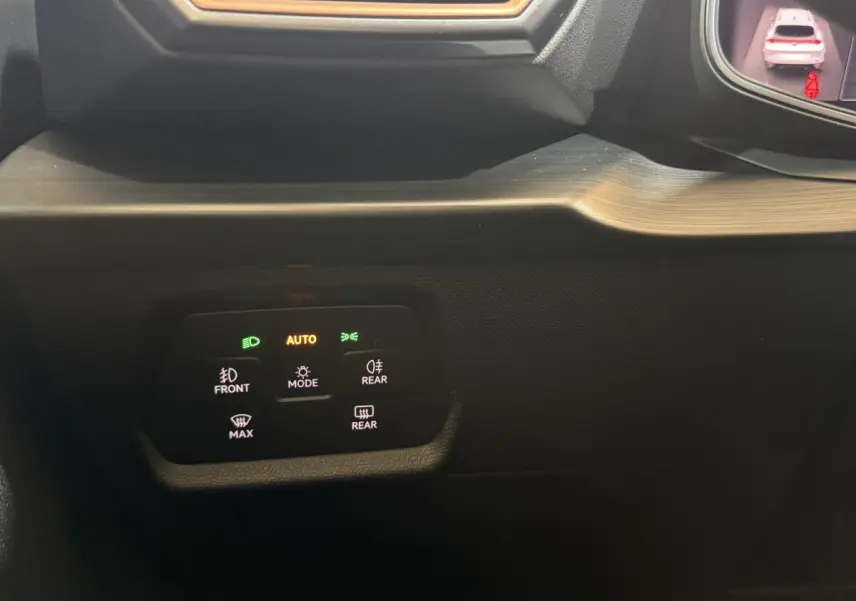 Gros plan sur les commandes d'éclairage avec affichage digital dans le tableau de bord du CUPRA Formentor noir 2023.