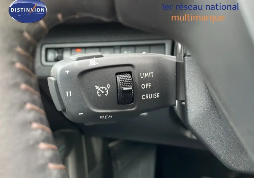 Gros plan sur la commande de régulateur de vitesse du Peugeot 3008 hybride, visible derrière le volant.