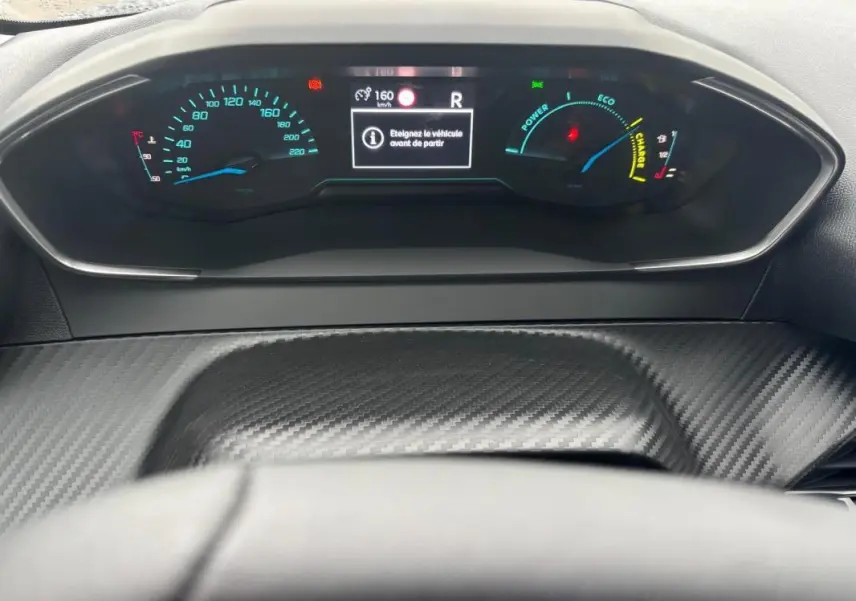 Vue rapprochée du cockpit numérique gris carbone de la Peugeot 208 Hybrid 100 e-DCS6 Style avec affichage digital et jauges colorées.