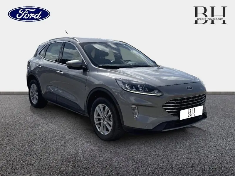 Ford Kuga 2023 gris Solar métallisé en vue 3/4 avant droit, avec calandre large et jantes alliage.