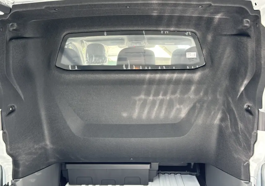 Vue intérieure de la cloison séparatrice noire du Renault Trafic cabine approfondie blanc, avec fenêtre vers l'avant.