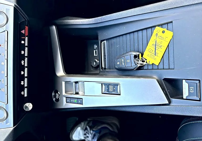 Vue plongeante sur la console centrale de la Peugeot 308 gris selenium avec clé et bouton de démarrage sans clé.