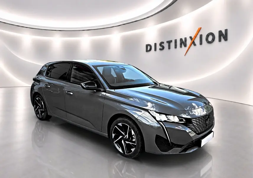 Peugeot 308 gris selenium vue 3/4 avant droit avec jantes alliage et calandre noire distinctive.