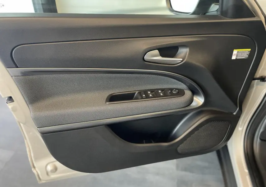 Gros plan sur la porte avant gauche beige métallisé de la FIAT 600 avec commandes de vitres et poignée argentée.