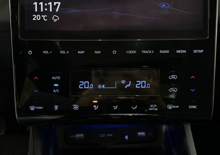 Gros plan sur la console centrale tactile du Hyundai Tucson noir, affichant la climatisation et commandes multimédia.