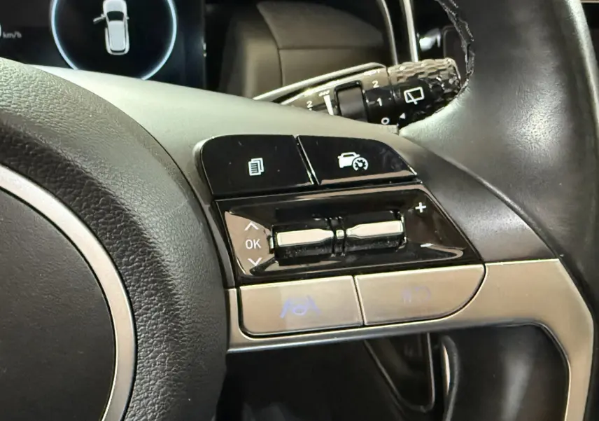 Gros plan sur les commandes multifonctions à droite du volant cuir noir du Hyundai Tucson hybride 2021.