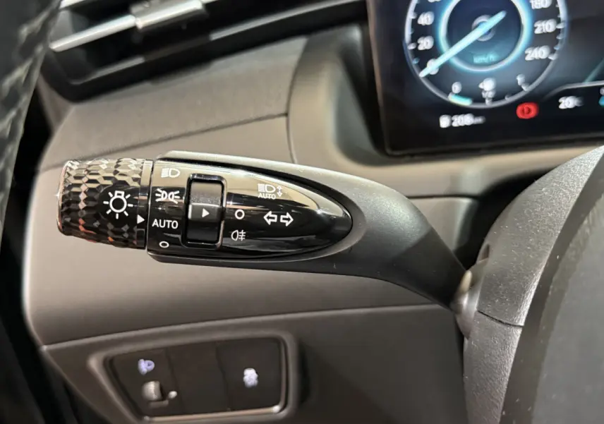 Gros plan sur la commande des feux et clignotants noire dans l'habitacle du Hyundai Tucson 2021 hybride noir.