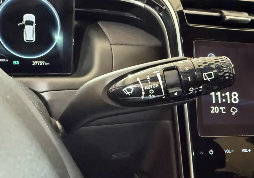 Gros plan sur la commande d’essuie-glace du Hyundai Tucson 2021 hybride, tableau de bord et écran tactile visibles.
