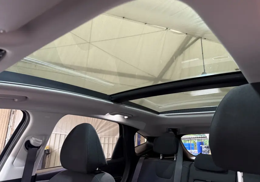 Vue intérieure arrière du Hyundai Tucson noir 2021 avec toit panoramique et sièges noirs visibles.