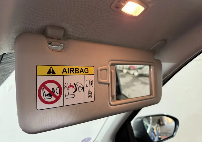 Détail du pare-soleil côté conducteur avec miroir intégré et avertissement airbag du Hyundai Tucson noir 2021.