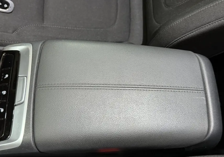 Coffre accoudoir central en cuir noir dans l'habitacle du Hyundai Tucson 2021, avec commandes visibles à gauche.