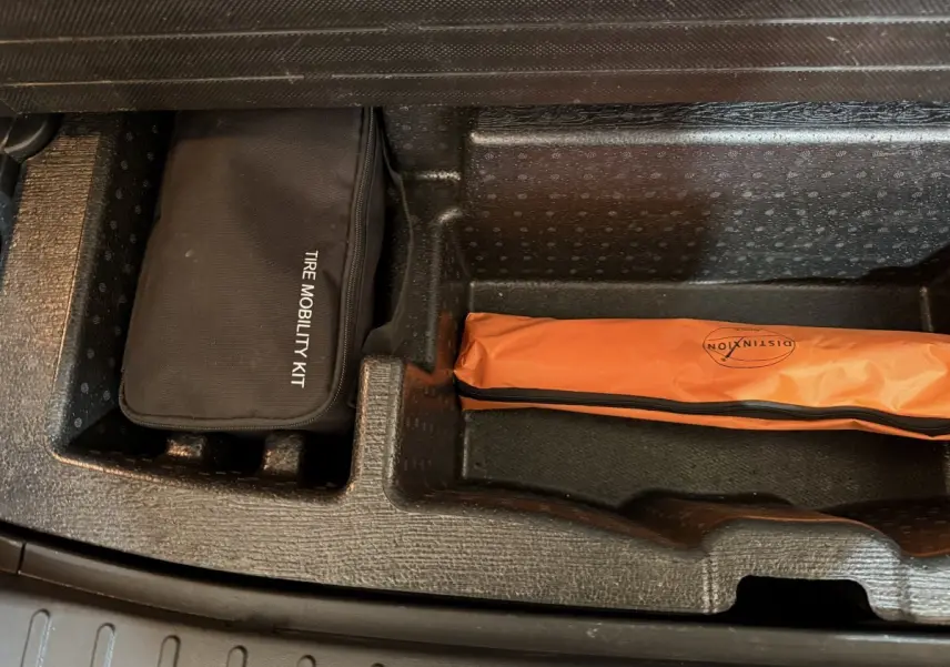 Rangement sous coffre du Hyundai Tucson 2021 avec kit mobilité noir et trousse orange de sécurité.