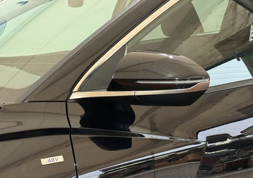 Gros plan sur le rétroviseur côté gauche noir brillant du Hyundai Tucson hybride 48V avec badge 48V visible sur la porte.
