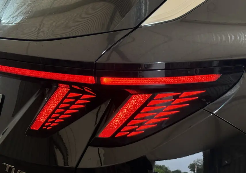 Gros plan sur le feu arrière droit rouge du Hyundai Tucson noir, soulignant son design lumineux moderne.